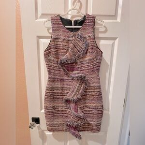 Textured tweed dress with fringe ruffle detail and a fitted silhouette.